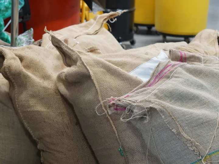 Burlap sacks of green coffee waiting at the roastery