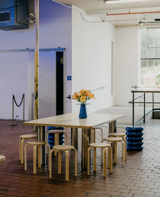 The communal table with flowers under factory windows