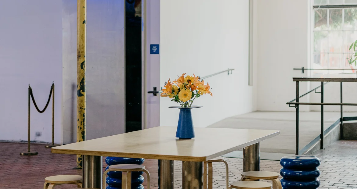 The communal table with flowers under factory windows