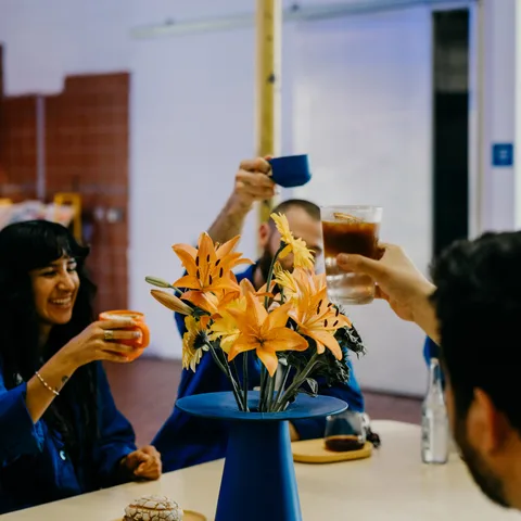 Two guests laughing over drinks and a pastry