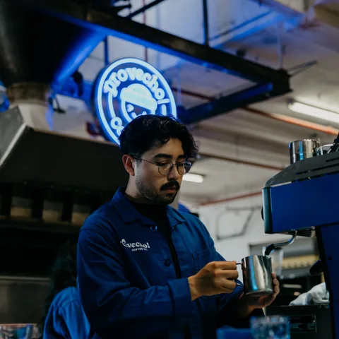A barista steaming milk behind the espresso bar