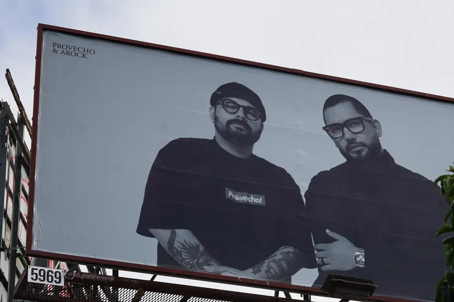 A roadside billboard carrying a black and white photograph of two men